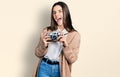 Young brunette teenager holding vintage camera smiling and laughing hard out loud because funny crazy joke Royalty Free Stock Photo