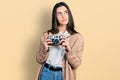 Young brunette teenager holding vintage camera smiling looking to the side and staring away thinking Royalty Free Stock Photo