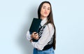 Young brunette teenager hugging laptop with love looking at the camera blowing a kiss being lovely and sexy Royalty Free Stock Photo