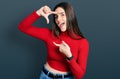 Young brunette teenager wearing red turtleneck sweater smiling making frame with hands and fingers with happy face Royalty Free Stock Photo