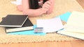 Young brunette using a calculator while lying on the floor