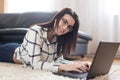 Young brunette using laptop on carpet