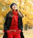 A young brunette in warm red Autumn clothes