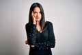 Young brunette woman with blue eyes wearing black casual sweater over white background thinking looking tired and bored with Royalty Free Stock Photo