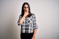 Young brunette woman with blue eyes wearing casual shirt and glasses over white background Looking fascinated with disbelief,