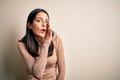 Young brunette woman with blue eyes wearing casual sweater over isolated white background hand on mouth telling secret rumor, Royalty Free Stock Photo