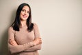 Young brunette woman with blue eyes wearing casual sweater over isolated white background happy face smiling with crossed arms Royalty Free Stock Photo