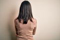 Young brunette woman with blue eyes wearing casual sweater over isolated white background standing backwards looking away with Royalty Free Stock Photo