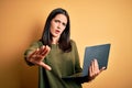 Young brunette woman with blue eyes working using computer laptop over yellow background doing stop gesture with hands palms, Royalty Free Stock Photo