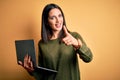 Young brunette woman with blue eyes working using computer laptop over yellow background pointing fingers to camera with happy and Royalty Free Stock Photo