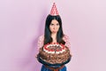 Young brunette woman celebrating birthday holding big chocolate cake depressed and worry for distress, crying angry and afraid Royalty Free Stock Photo