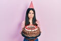 Young brunette woman celebrating birthday holding big chocolate cake relaxed with serious expression on face Royalty Free Stock Photo