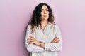 Young brunette woman with curly hair wearing casual clothes skeptic and nervous, disapproving expression on face with crossed arms Royalty Free Stock Photo