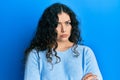 Young brunette woman with curly hair wearing casual clothes skeptic and nervous, disapproving expression on face with crossed arms Royalty Free Stock Photo