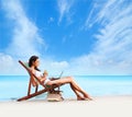 A young brunette woman drinking a cocktail and relaxing on the beach Royalty Free Stock Photo