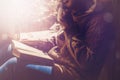 Young brunette woman drinking a cup of tea or coffee and reading a book. Female sitting at home by the window and read a book Royalty Free Stock Photo