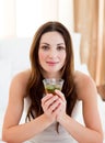 Young brunette woman drinking tea sitting on bed Royalty Free Stock Photo