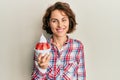 Young brunette woman eating strawberry ice cream looking positive and happy standing and smiling with a confident smile showing