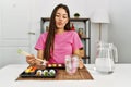 Young brunette woman eating sushi using chopsticks making fish face with lips, crazy and comical gesture Royalty Free Stock Photo