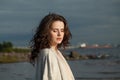 Young brunette woman with fresh skin, natural make-up and healthy wavy brown hair enjoying the sunny morning and sea air. Royalty Free Stock Photo