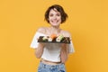 Young brunette woman girl in casual clothes hold in hand makizushi sushi roll served on black plate traditional japanese Royalty Free Stock Photo