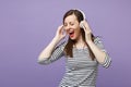 Young brunette woman girl in casual striped clothes posing isolated on violet purple background studio portrait. People Royalty Free Stock Photo