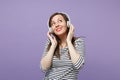 Young brunette woman girl in casual striped clothes posing isolated on violet purple background studio portrait. People Royalty Free Stock Photo