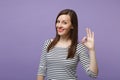 Young brunette woman girl in casual striped clothes posing isolated on violet purple background studio portrait. People Royalty Free Stock Photo