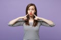 Young brunette woman girl in casual striped clothes posing isolated on violet purple background studio portrait. People Royalty Free Stock Photo