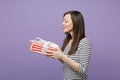 Young brunette woman girl in casual striped clothes posing isolated on violet purple background studio portrait. People Royalty Free Stock Photo