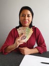 young brunette woman grabbing and showing Mexican money