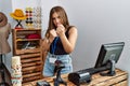 Young brunette woman holding banner with open text at retail shop ready to fight with fist defense gesture, angry and upset face, Royalty Free Stock Photo