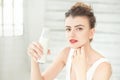 Young brunette woman holding a bottle of soy milk in her hand sitting in a bright room.Healthy Lifestyle Concept Royalty Free Stock Photo