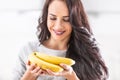 Young brunette woman holding a bunch of bananas Royalty Free Stock Photo