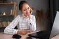 Young brunette woman holding credit card and using laptop computer working at home. Businesswoman making online shopping Royalty Free Stock Photo