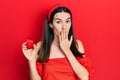 Young brunette woman holding engagement ring for proposal covering mouth with hand, shocked and afraid for mistake Royalty Free Stock Photo