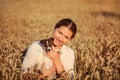 Young brunette woman holding Jack Russell terrier puppy on her hands, smiling, sunset lit wheat field behind her Royalty Free Stock Photo
