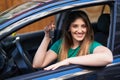 Young brunette woman holding key of new car looking positive and happy standing and smiling with a confident smile showing teeth Royalty Free Stock Photo