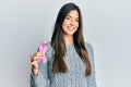 Young brunette woman holding pink cancer ribbon looking positive and happy standing and smiling with a confident smile showing Royalty Free Stock Photo