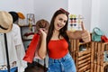 Young brunette woman holding shopping bags at retail shop approving doing positive gesture with hand, thumbs up smiling and happy Royalty Free Stock Photo