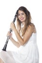 Young brunette woman holds clarinet in studio and smiles