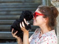 Young brunette woman hugging her lap dog puppy