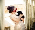 Young brunette woman hugging her lap dog puppy