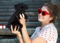 Young brunette woman hugging her lap dog puppy