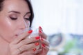 young brunette woman in kitchen wearing pink dressing gown with a cup of hot beverage coffee. tender woman portrait Royalty Free Stock Photo