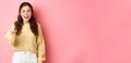 Young brunette woman laughing, smiling amazed and pointing at camera, choosing you, standing against pink background Royalty Free Stock Photo