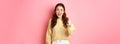 Young brunette woman laughing, smiling amazed and pointing at camera, choosing you, standing against pink background Royalty Free Stock Photo