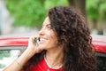 Young brunette woman leaning on her car and talking on a cell phone Royalty Free Stock Photo