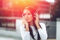 Young brunette woman listening to music by headphones outdoor Royalty Free Stock Photo