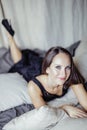 Young brunette woman in loft laying on bed smiling Royalty Free Stock Photo